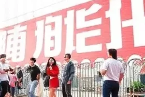 楼道口放着一个贴有标签的旧行李箱